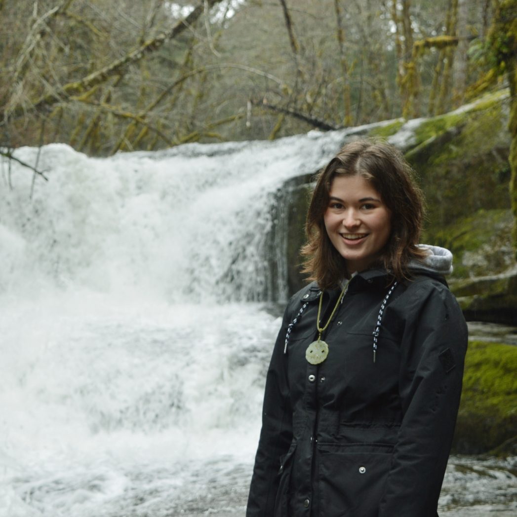 Graduate Student standing beside a waterfall 